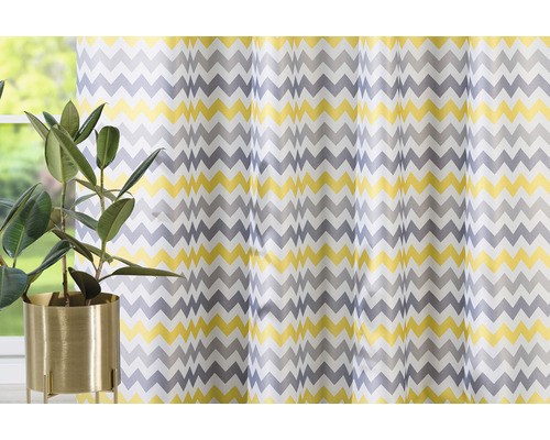 Dekorační šály s cikcakovým vzorem před oknem