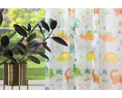 Dekorativní šály s dinosauřím vzorem v dětském pokoji a pokojová rostlina v květináči.