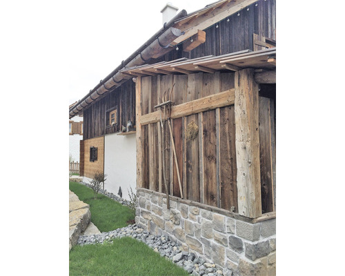 Dřevěný dům s kamennými základy a zahradní úpravou