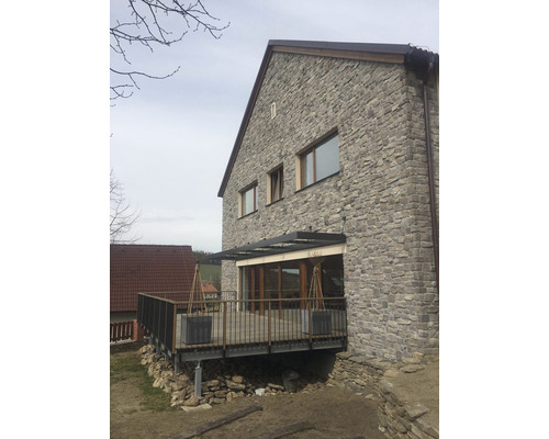 Pohled na dům s kamennou fasádou a terasou