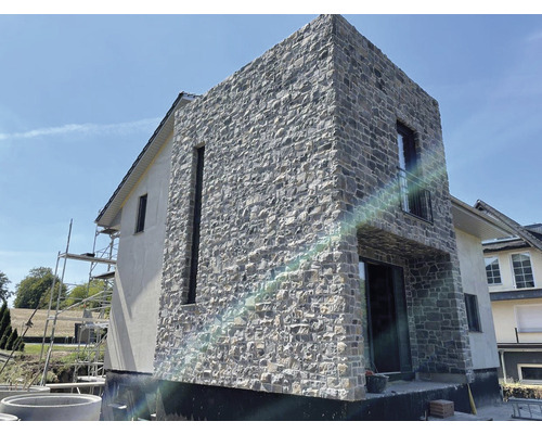 Fasáda domu s obkladem z přírodního kamene a omítkou