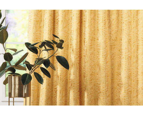 Dekorativní šály s rostlinným vzorem vedle pokojové rostliny