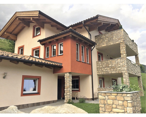 Vnější pohled na dům s balkony, kamennými sloupy a střechou