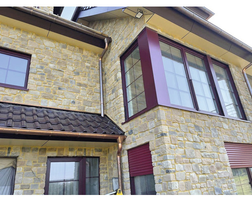 Exteriér domu s kamenným obkladem, okny a okapy