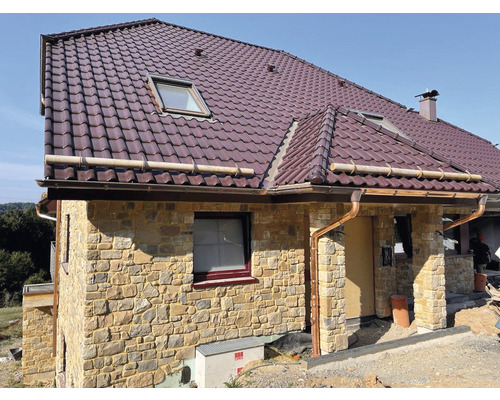 Dům s kamennou fasádou, střešními okny a systémem odvodnění střechy