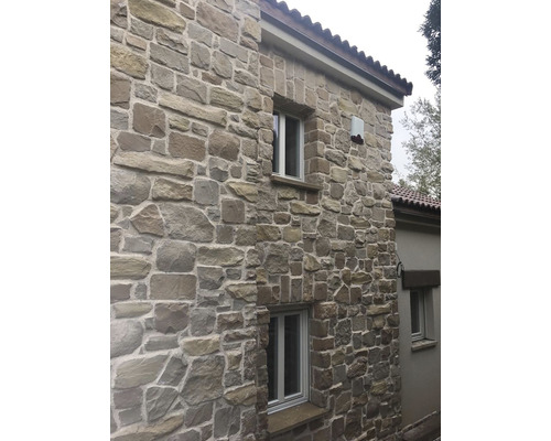 Fasáda domu s obkladem z přírodního kamene a okny