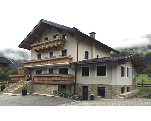 Vícepodlažní obytný dům s balkony a kamennou fasádou