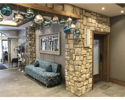 Interiér wellness centra s pohovkou, zrcadlem a dekorací