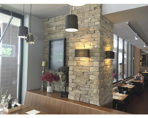 Interiér restaurace s kamenným sloupem a lampami