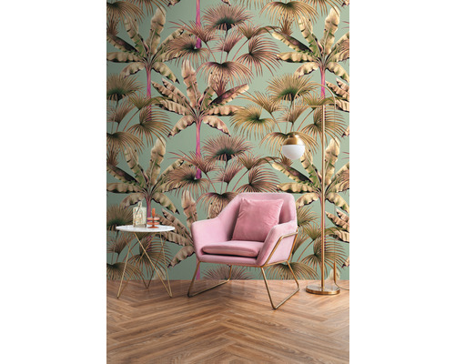 Pohled do místnosti s tapetou s palmovým vzorem, křeslem, odkládacím stolkem a stojací lampou