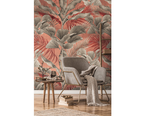 Obývací pokoj s křeslem, stolem a dekorací před stěnou s tapetou s listy