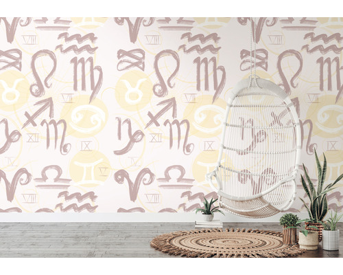 Pokoj s tapetou se vzorem znamení zvěrokruhu, závěsné ratanové křeslo a pokojové rostliny