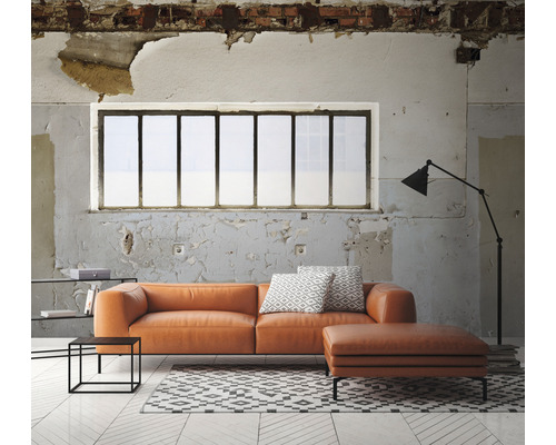 Obývací pokoj s oranžovou koženou pohovkou, otomanem, kobercem a stojací lampou před oknem