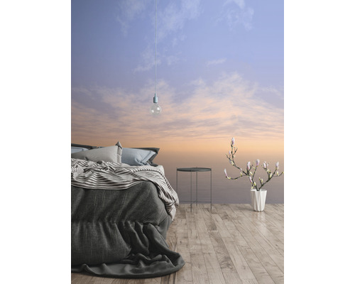 Ložnice s postelí, odkládacím stolkem, vázou na květiny a tapetou s motivem oblohy