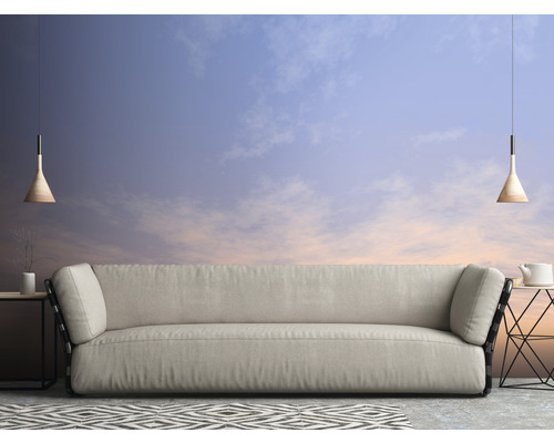 Obývací pokoj s pohovkou, odkládacími stolky, závěsnými svítidly a vzorovaným kobercem