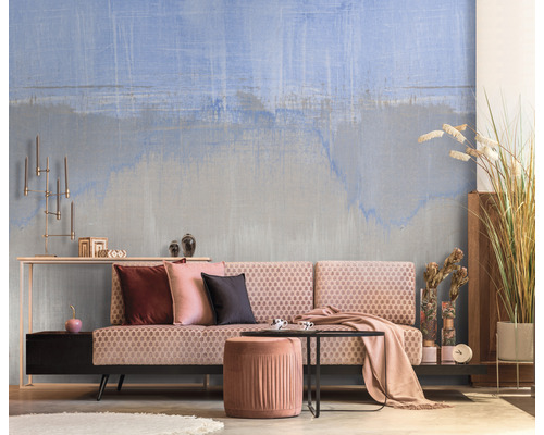 Obývací pokoj s vzorovanou tapetou, pohovkou, stoličkou a dekorací