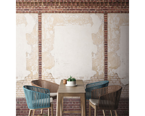 Terasa s stolem a židlemi před cihlovou zdí