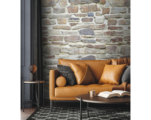 Obývací pokoj s pohovkou, polštáři, stolem a tapetou s kamennou zdí