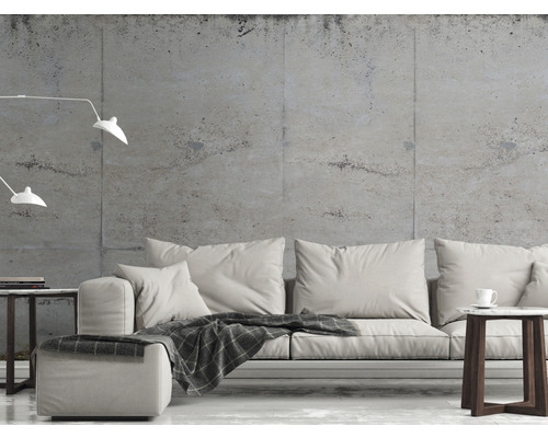 Obývací pokoj s pohovkou, odkládacím stolkem a stojací lampou před betonovou stěnou