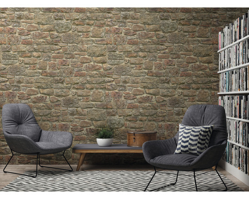 Obývací pokoj s tapetou kamenné zdi, dvě křesla, koberec a knihovna