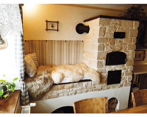 Zděná kamna s posezením a polštáři v obývacím pokoji