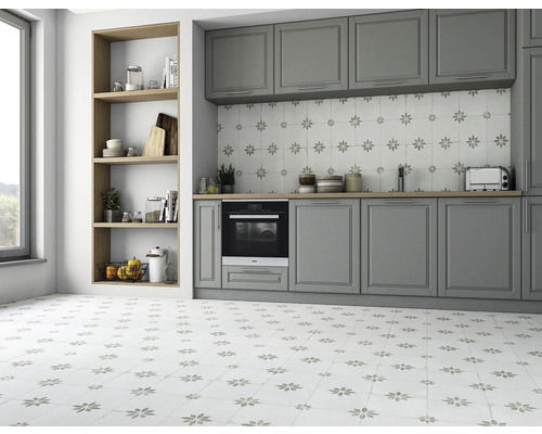 Světlá kuchyně se šedými skříňkami a dlaždicemi s květinovým vzorem