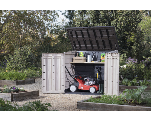 Zahradní scéna se zahradní skříní s otevřenými dveřmi, sekačkou na trávu a zahradním nářadím