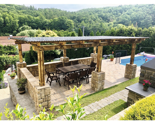 Zastřešené posezení s dřevěnou konstrukcí, kamennými sloupy a zahradní jídelní sestavou vedle bazénu