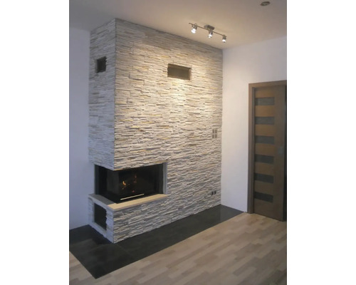 Obývací pokoj s krbem, obložený kamennými panely a vybavený osvětlovací lištou