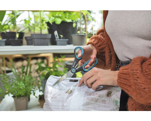 Osoba otevírá balení zeminy pro výsev a bylinky nůžkami značky Gardena.