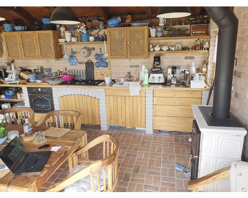 Interiér rustikální kuchyně s dřevěným nábytkem, spotřebiči a dekoracemi