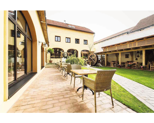 Venkovní prostor se stoly, židlemi a vodním kolem