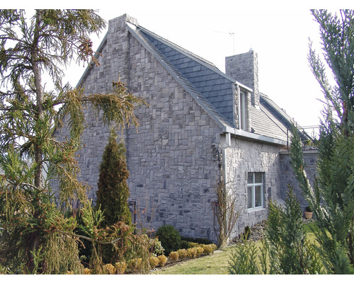 Vnější pohled na dům s kamennými zdmi a břidlicovou střechou.