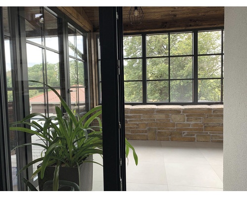 Prosklená zimní zahrada s kamennou zdí a rostlinami