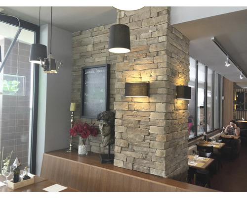 Interiér restaurace s kamenným sloupem a osvětlením