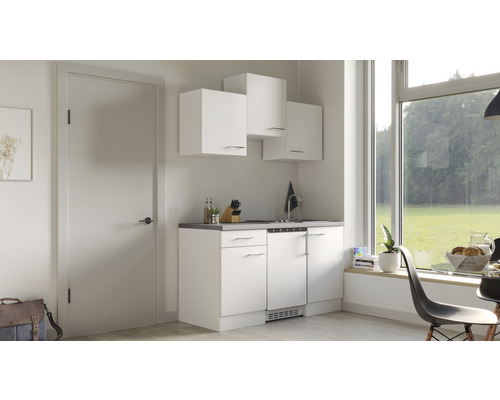 Malá kuchyň s bílými skříněmi a výhledem z okna.