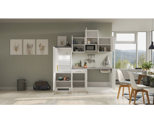 Kuchyňská linka s lednicí, dřezem a závěsnými skříňkami ve světlé místnosti