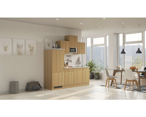 Kompletní kuchyňská linka se skříňkami, dřezem, mikrovlnnou troubou a digestoří ve světlém, moderním pokoji.