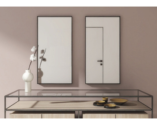 Dvě obdélníková zrcadla visí nad konzolovým stolkem, který je zdobený dekorativními předměty.