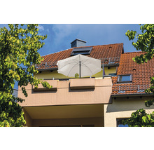 Balkon se slunečníkem a výsadbou před domem