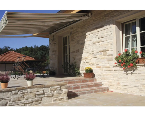 Fasáda domu s markýzou, kamenné schody a osázení