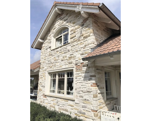 Exteriér domu s fasádou z přírodního kamene a bílými okenními rámy