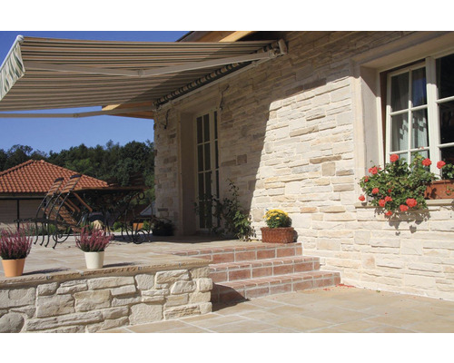 Fasáda domu s markýzou, kamenné schody a osázené květináče