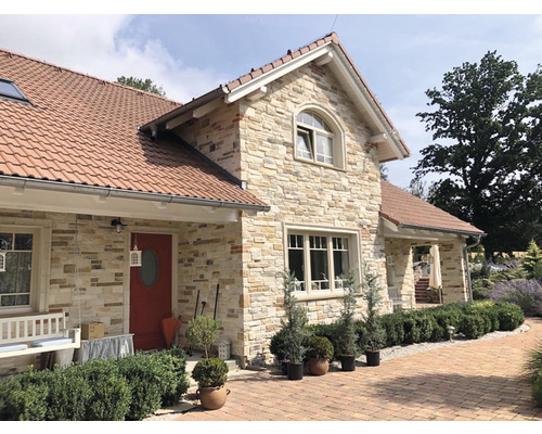 Fasáda domu s obkladovými kameny a červenou střechou