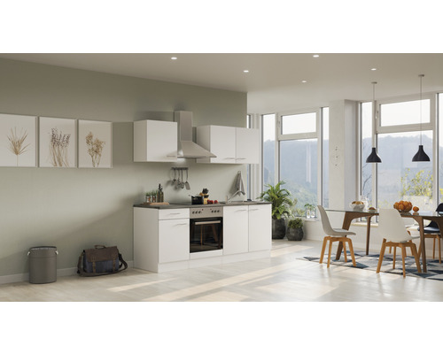 Světlá, moderní kuchyně s bílými skříňkami a jídelním koutem v prostorném pokoji.