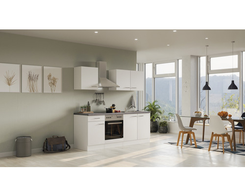 Světlá, přátelská kuchyně s bílými skříňkami, digestoří a jídelním koutem