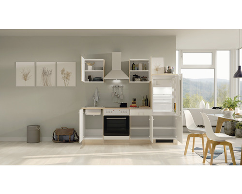 Vestavěná kuchyně s elektrickými spotřebiči ve světlé místnosti s jídelním stolem