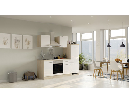 Světlá vestavěná kuchyně s elektrickými spotřebiči a jídelním koutem v moderně zařízeném pokoji.