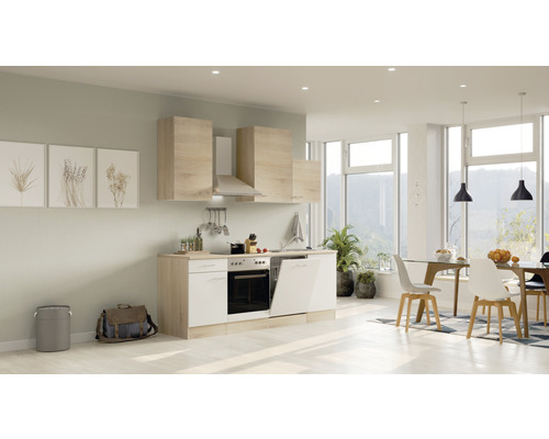 Světlá kuchyně s horními a dolními skříňkami, digestoří, dřezem a myčkou v prostorném obývacím pokoji