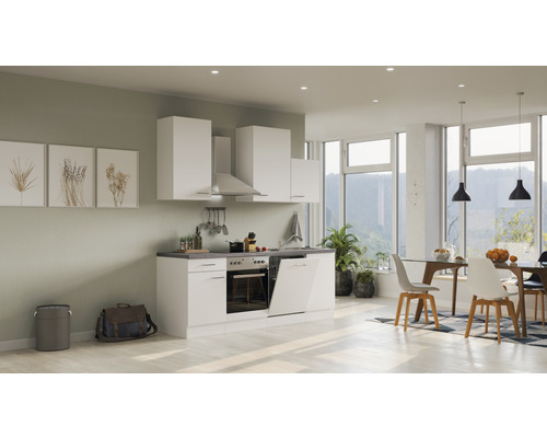 Světlá kuchyně s bílými skříňkami, digestoří a jídelním koutem